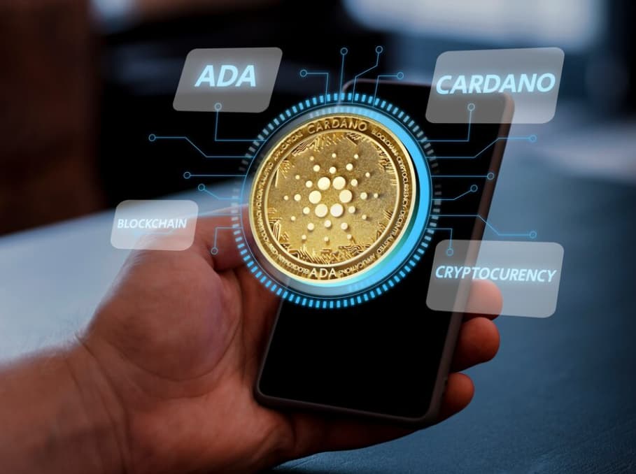 A golden Cardano coin with circuit connections is held over a smartphone