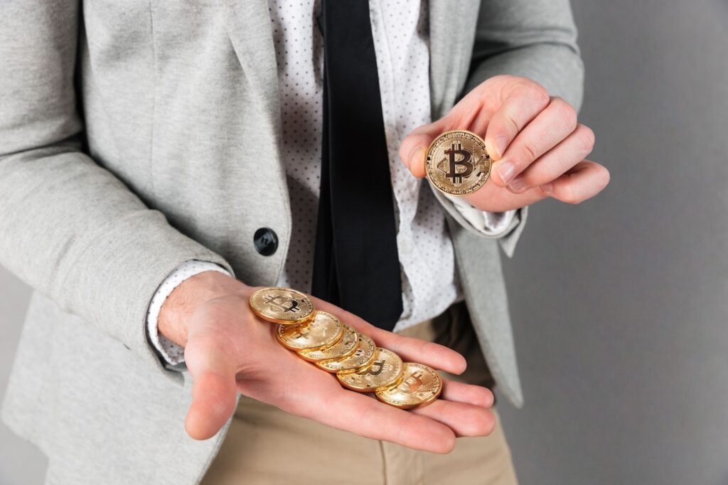 Close up of man holding stack of golden bitcoins