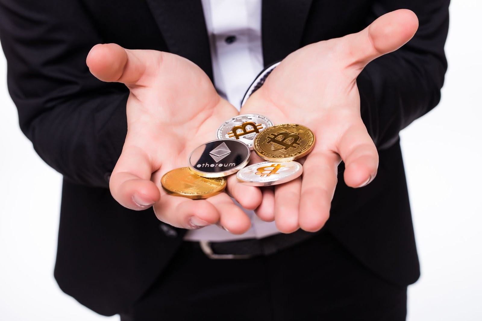 Man holds different crypto coins in his hands